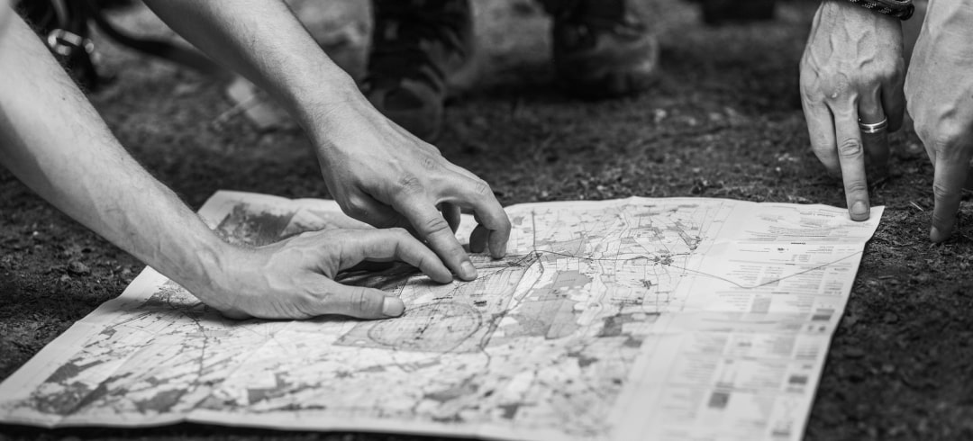 two people's hands resting on a map